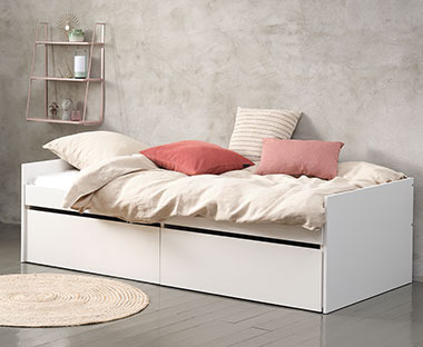 Krevet bele boje sa posteljinom i šarenim jastučićima u spavaćoj sobi