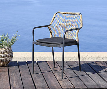 Crna baštenska stolica na terasi uz more