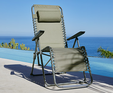 Udobna stolica za kampovanje zelene boje pored bazena