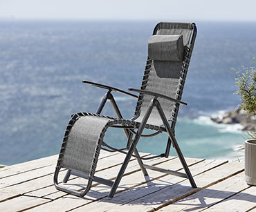 Relaks stolica sive boje na terasi uz more