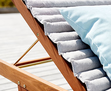 baštenski jastuk za ležaljke svetlo sive boje na ležaljci od drveta