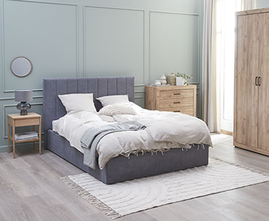 Sivi ram kreveta u spavaćoj sobi plavih zidova