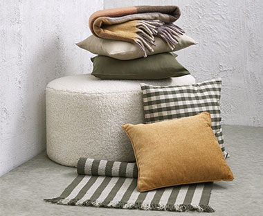 Ukrasni jastuci i tekstili na taburei i podu
