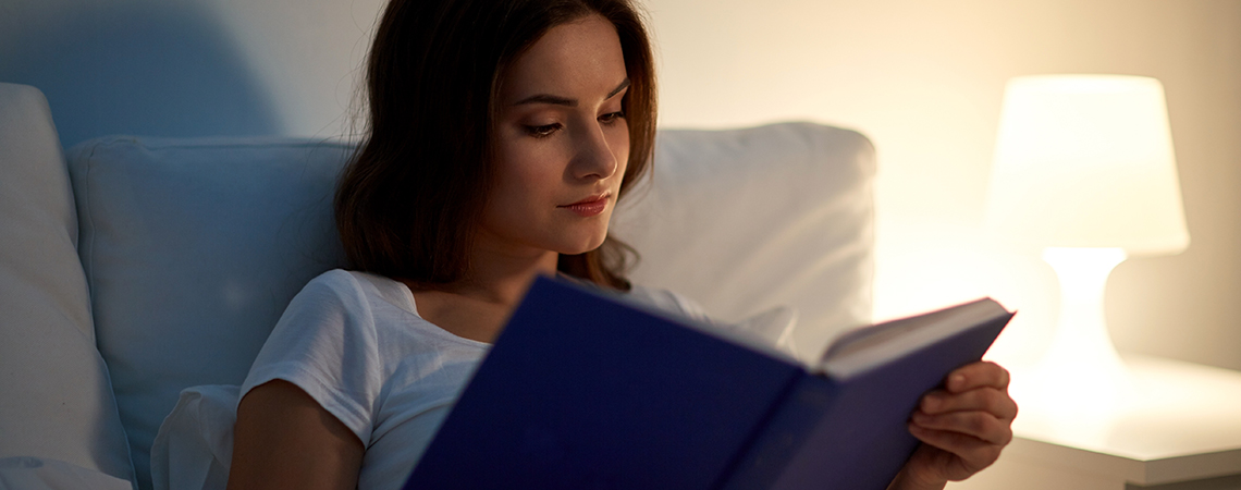 Žena čita knjigu u krevetu