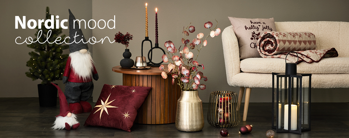 Novogodišnji vilenjaci, jastuci, zlatna vaza sa veštačkim cvećem, zlatni svećnjak i crni fenjer