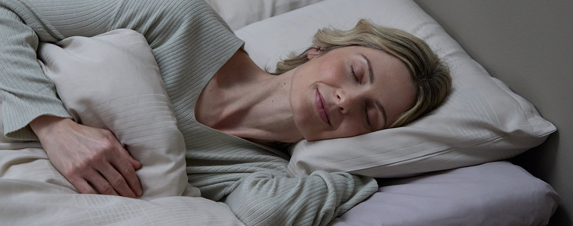 Žena spava na jastuku od memorijske pene