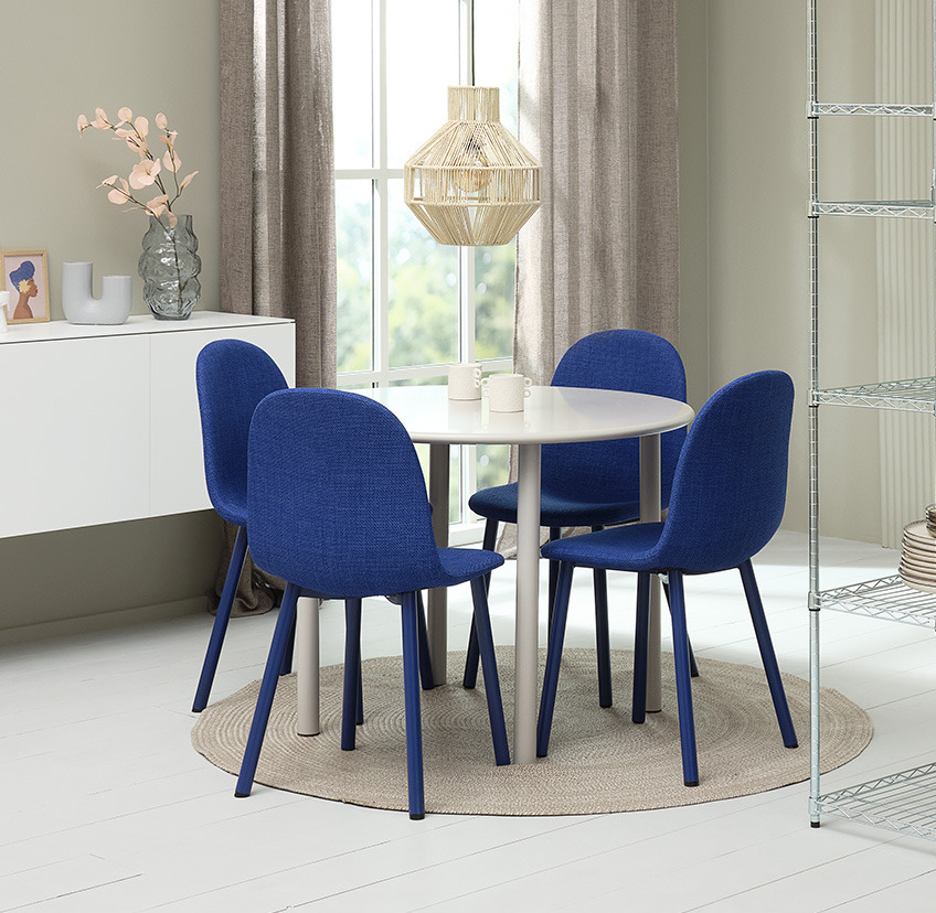 Jarko plave trpezarijske stolice i beli okrugli trpezarijski sto
