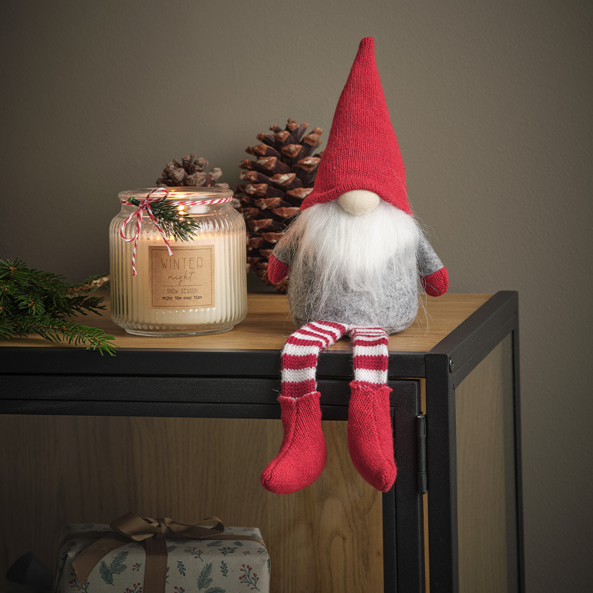 Božićni vilenjak sa belom bradom, crvenom kapom i crveno-belim čarapama