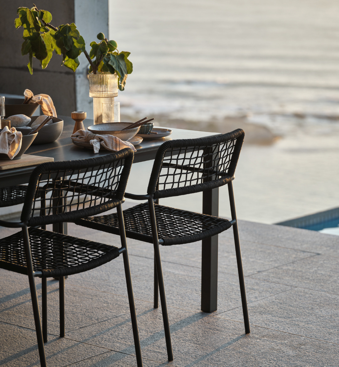 Čelične crne baštenske stolice uz crni baštenski sto na terasi