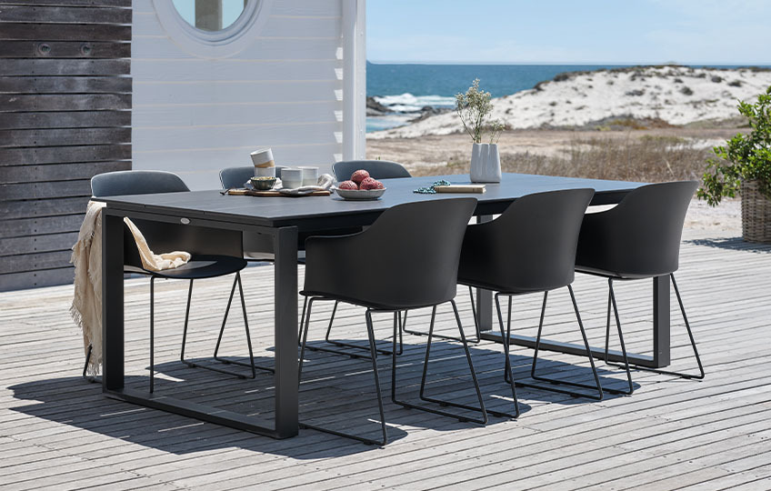 Veliki baštenski sto i stolice na terasi pored plaže