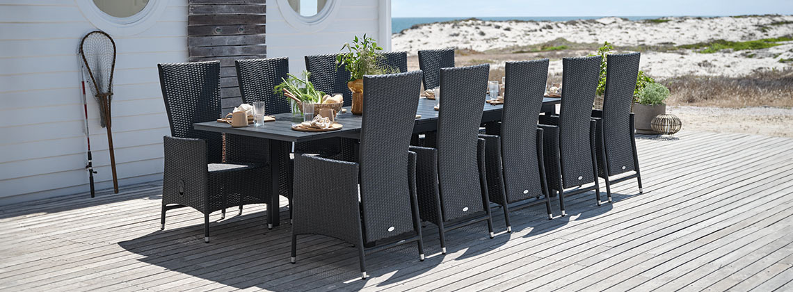 Veliki baštenski sto i stolice za 10 ili 12 osoba na terasi pored plaže
