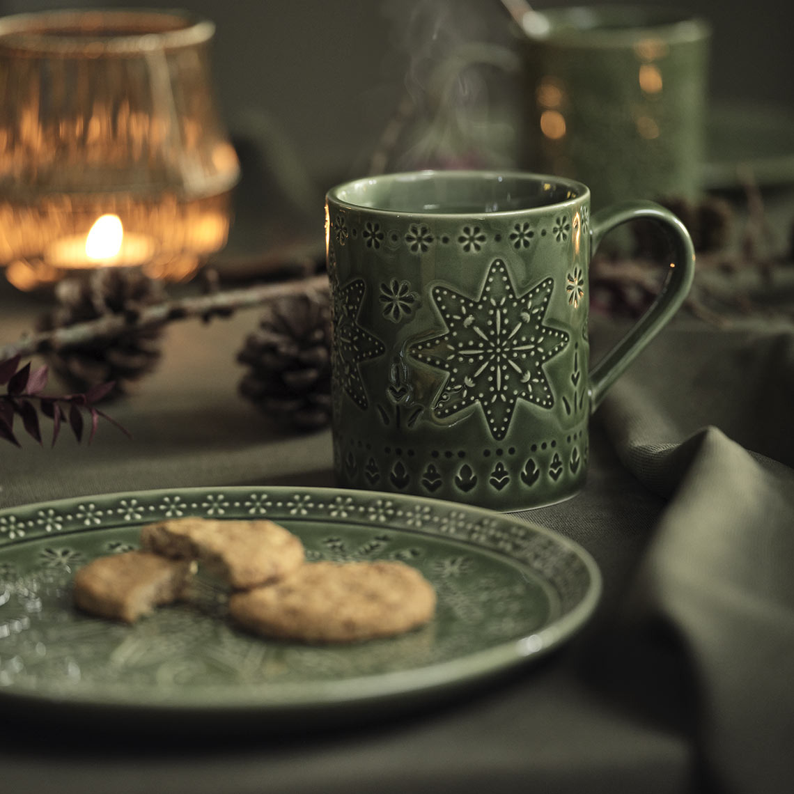 Green Christmas plate and mug on a Christmas table 