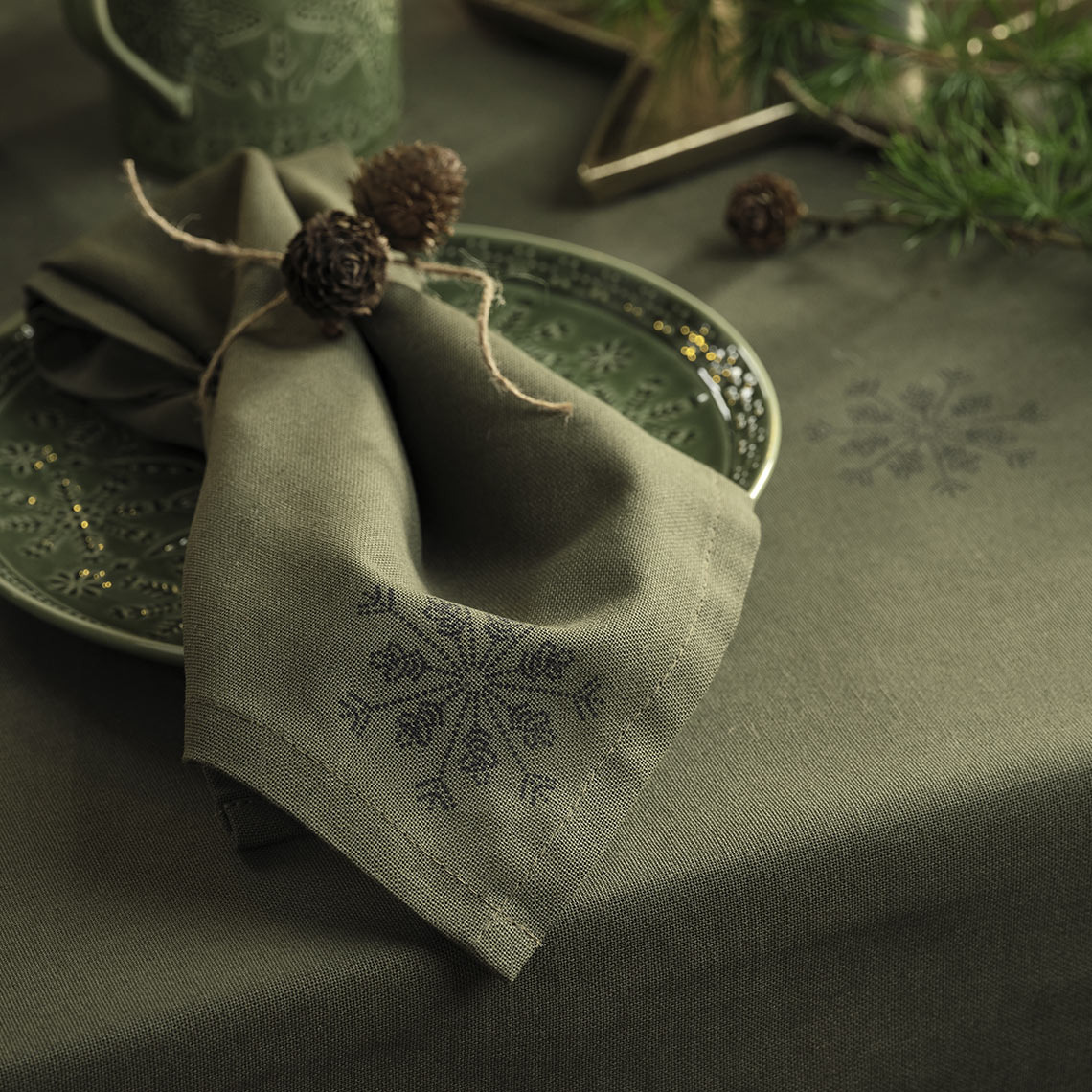 Green Christmas tablecloth and Christmas cloth napkin on a green plate 
