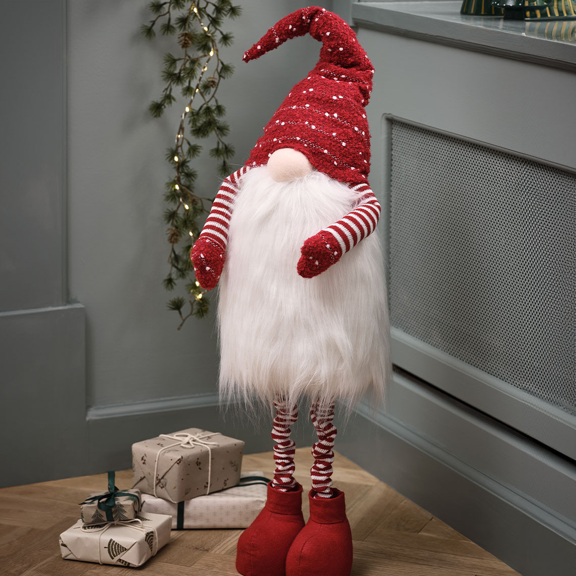 Visoki novogodišnji vilenjak sa crvenom kapom i velikom bradom 