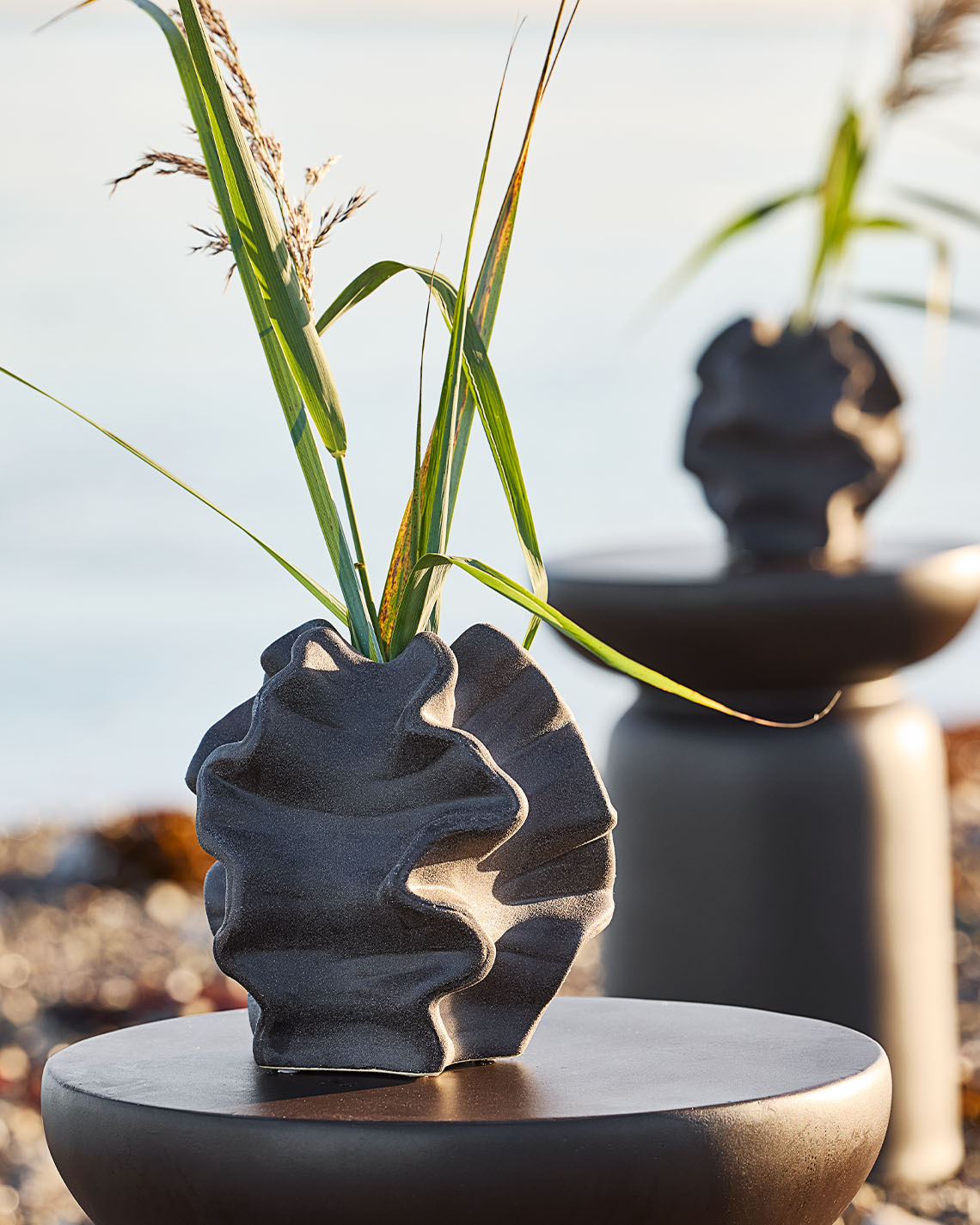 Vaza organskog oblika na postolju na plaži