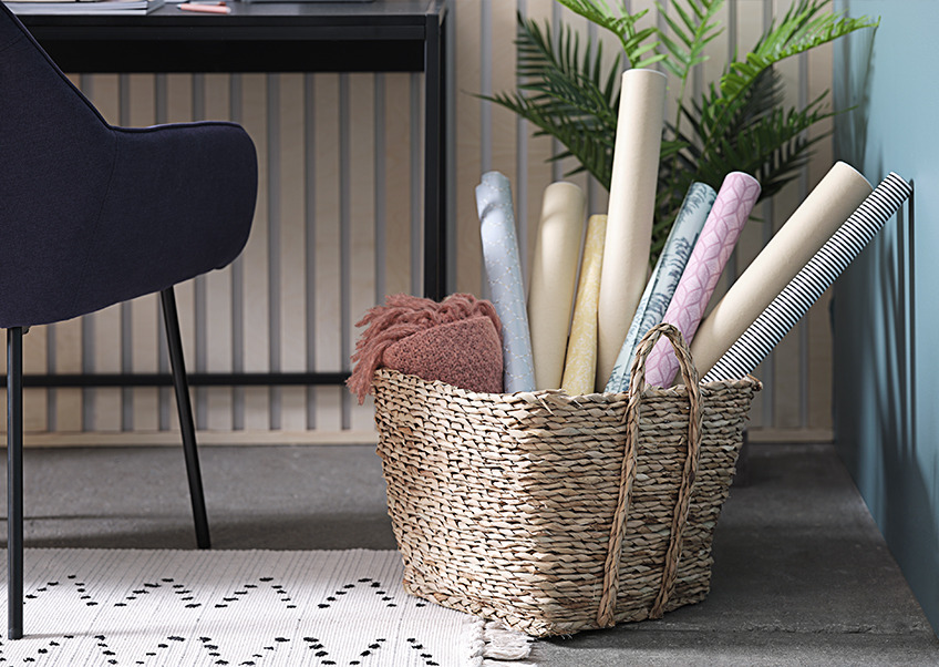 Basket with a throw and rolls of gift wrapping paper Basket with a throw and rolls of gift wrapping paper