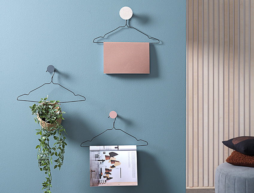 Hangers on a wall with magazines and an artificial plant Hangers on a wall with magazines and an artificial plant