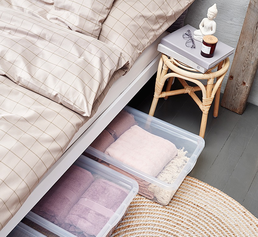 Krevet sa bež posteljinom i kutijama za ispod kreveta