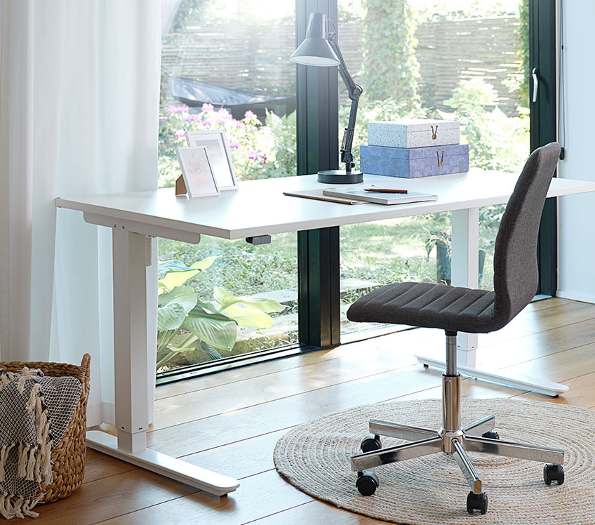 Kancelarijska stolica od tkanine i podesiv radni sto pored prozora