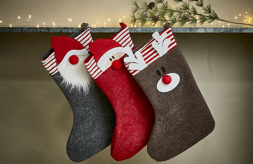 Novogodišnje čarape sa različitim motivima vise na polici
