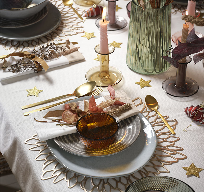 Sivi i plavi tanjiri i zlatni pribor za jelo na novogodišnjem stolu