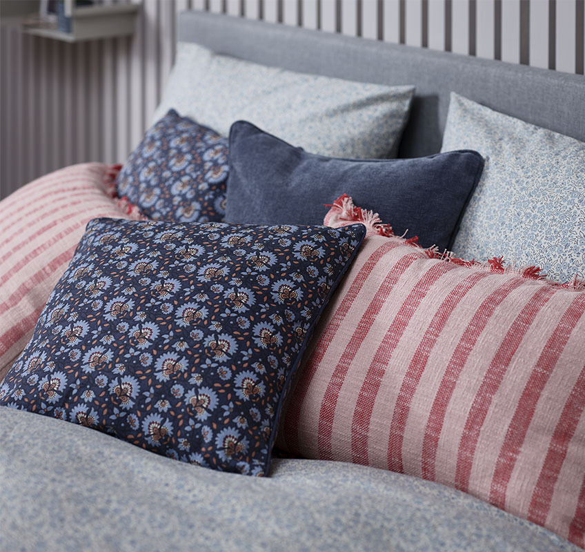 Krevet sa ukrasnim jastucima plavih i crvenih nijansi