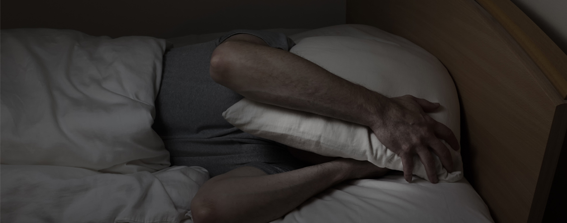 Osoba pokriva glavu jastukom
