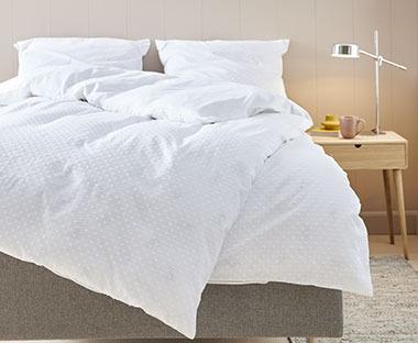 Bela posteljina od 100% pamuka na krevetu u spavaćoj sobi