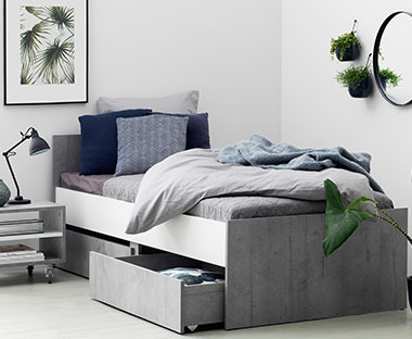 okvir kreveta sivo bele boje sa fiokom u spavaćoj sobi