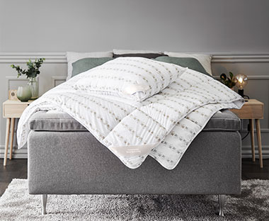 Jorgan i jastuk na sivom krevetu