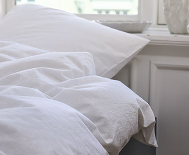 Pamučna bela posteljina na krevetu u spavaćoj sobi